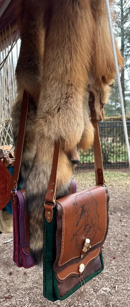 Handcrafted leather satchels with fox tooling and antler toggle
